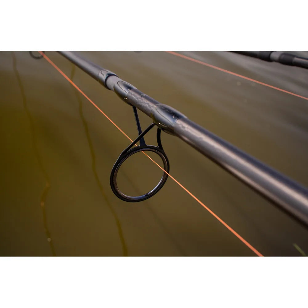 Detalhe de um passador Seaguide com anel SIC da cana Mikado Noctis X Spod, com linha laranja, durante uma sessão de pesca de carpa.