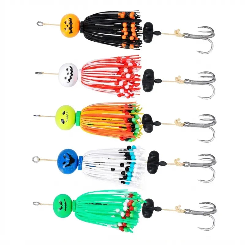 Catálogo visual com cinco amostras de pesca para siluro e grandes predadores, alinhadas verticalmente. Cada amostra possui uma cabeça com design de abóbora de Halloween (cores laranja, branca, verde-lima, azul e verde), saias de silicone com missangas coloridas, destorcedor e anzol triplo, isoladas sobre fundo branco.
